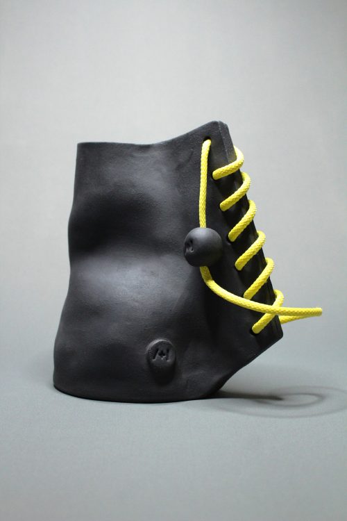 Sculpture haute couture n°1. Grès noir et lacet jaune.
